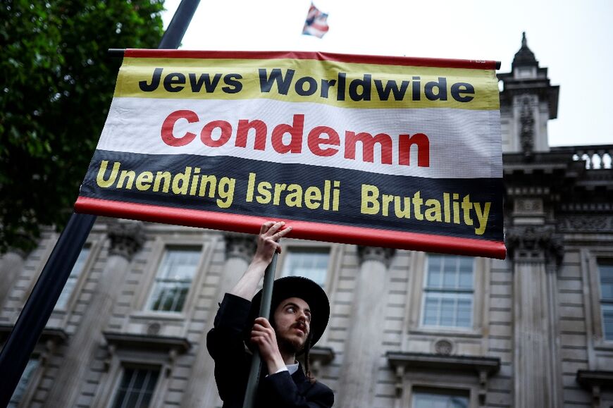 A member of the ultra-Orthodox Jewish community holds a placard outside Downing Street, central London