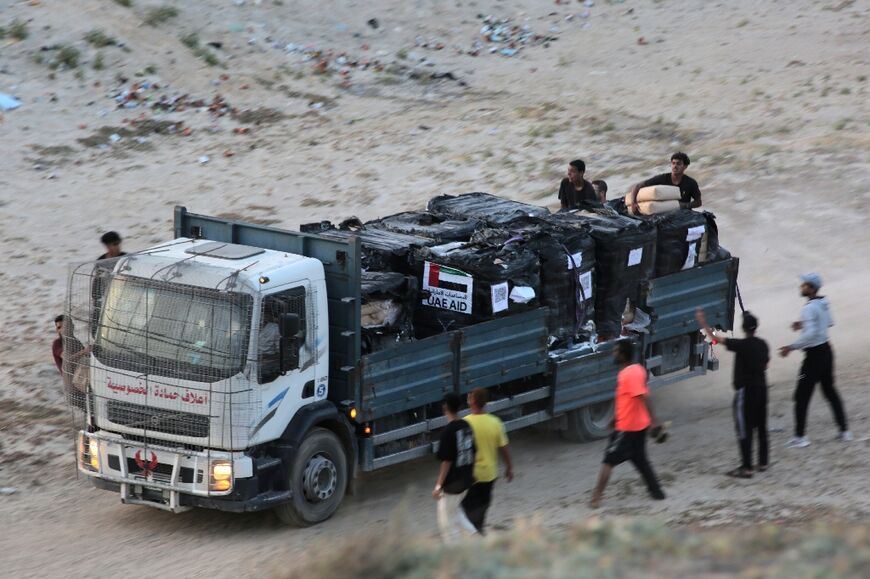 Palestinians rush a truck as it transports humanitarian aid from the US-built Trident Pier, near Nuseirat in the central Gaza Strip 