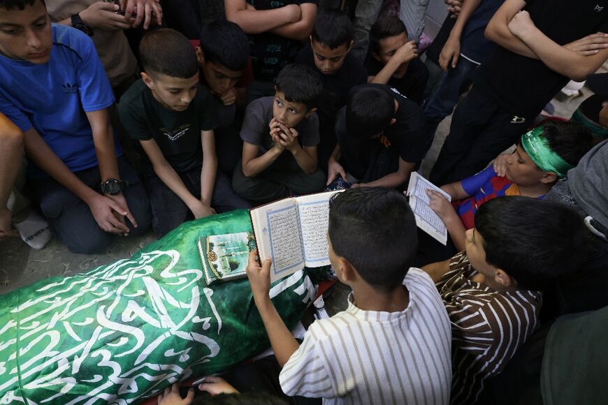 Schoolchildren in the West Bank city of Jenin recite funeral prayers over the shrouded body of their teacher, Allam Jaradat, who Palestinian officials say was killed in an Israeli raid