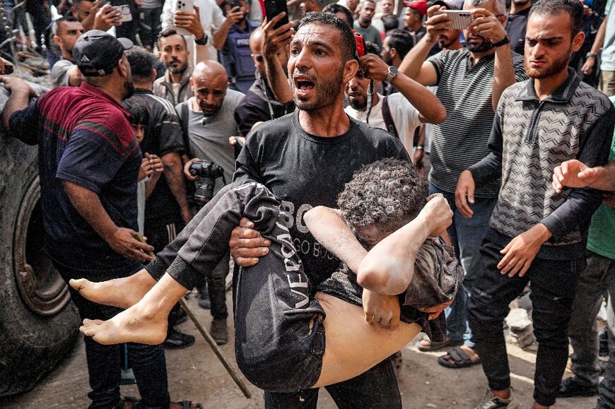 A man carries a victim recovered from the rubble of a collapsed building after Israeli bombardment in Nuseirat, central Gaza