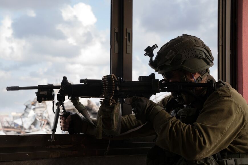 A photo released by the Israeli army, which said it shows a soldier aiming a machine gun from a building in the Zeitun area of Gaza City, north Gaza