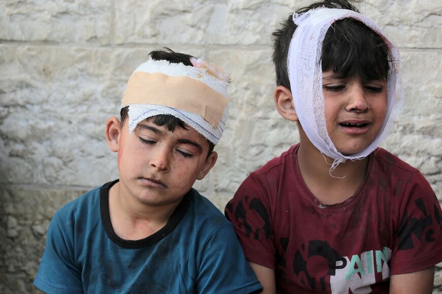 Injured Palestinian boys at Al-Aqsa Martyrs Hospital react as their family waits to identify bodies of relatives killed in Israeli bombardment