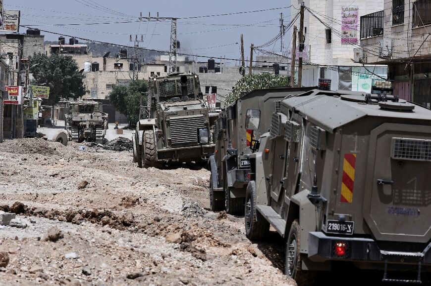 An Israeli bulldozer strips the asphalt from a main road in Jenin as armoured vehicles mount a deadly raid in the northern West Bank city