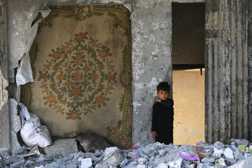 A Palestinian boy stands amid the rubble in a building heavily damaged by an Israeli airstrike in Rafah in the southern Gaza Strip on May 22, 2024