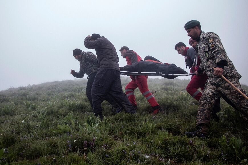Rescuers recover bodies at the crash site of the helicopter 