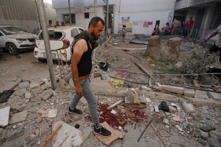 Palestinians inspect the aftermath of an Israeli strike on a building in Gaza's Nuseirat