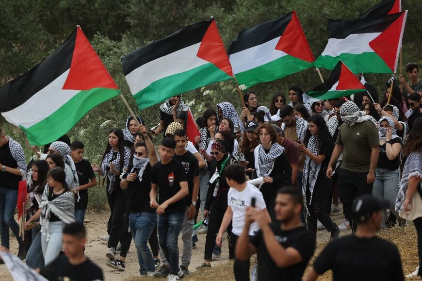 Arab-Israeli protesters wave Palestinian national flags during a rally near Israel's northern city of Shefa Amr