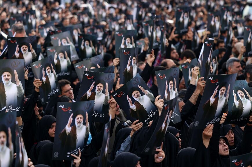 Mourners holding photographs of the late president gather on Monday evening in Tehran's Valiasr Square