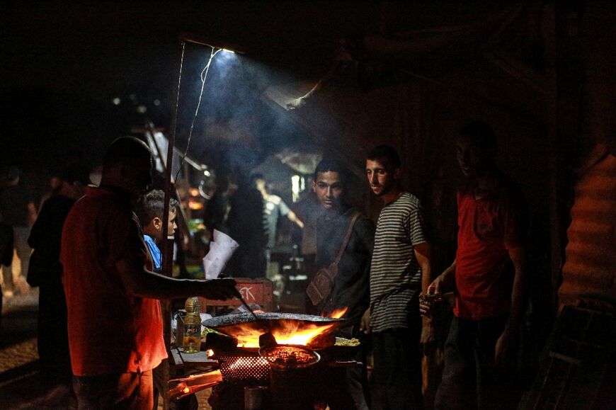 Food vendors along a street with no lights in central Gaza, where power supply and other basics have been limited by the war