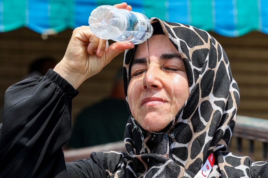 A Turkish pilgrim pours cold water on her head to cool off in Saudi Arabia's holy city of Mecca