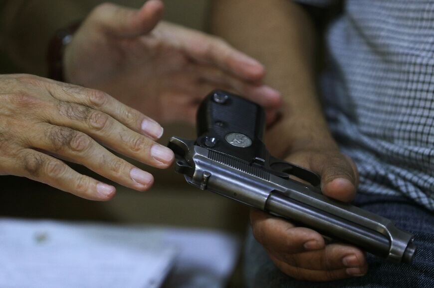 A police officer registers a weapon at a private home in Baghdad