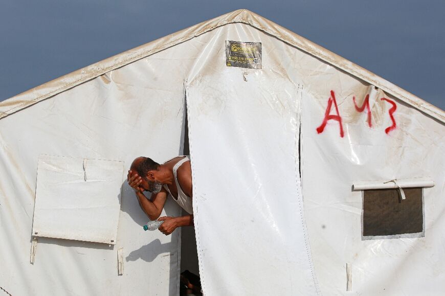 A man washes his face at a tent sheltering displaced Palestinians in the al-Mawasi area of southern Gaza -- more than one million people have been forced from nearby Rafah since Israeli military operations began there in May 2024, the UN says