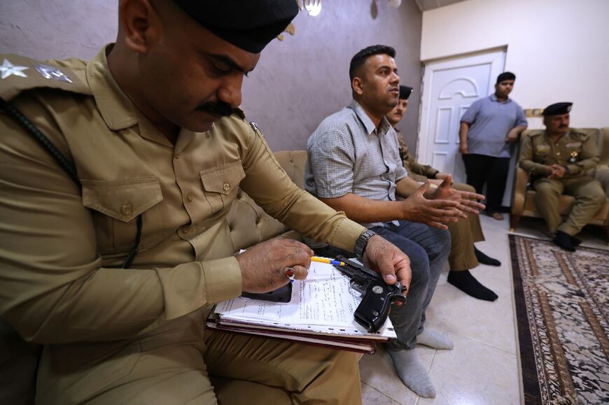 Police register a private citizen's weapon at a house in Iraq's capital Baghdad