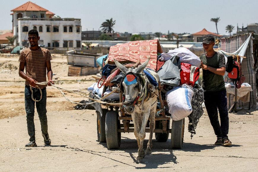 Displaced Palestinians and a donkey cart piled with belongings as they flee northwest Rafah