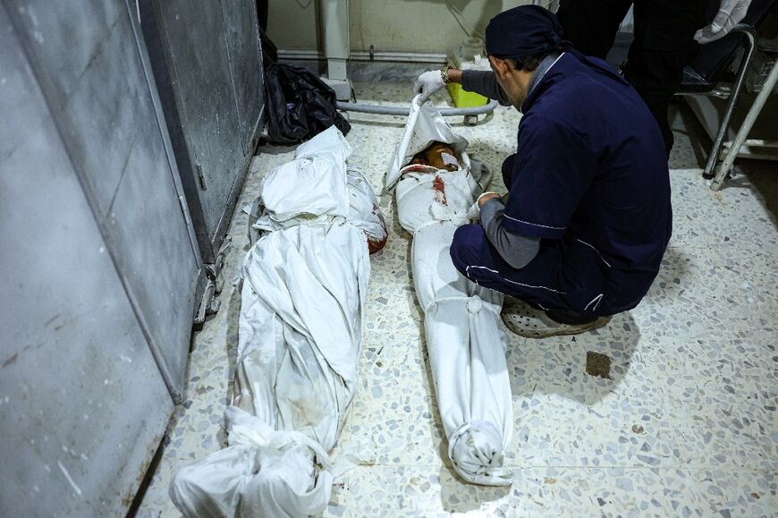 A medical worker covers a body at the hospital in Idlib