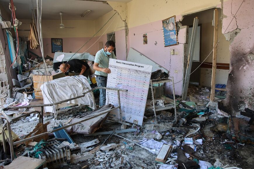 Palestinians inspect the rubble at al-Daraj clinic in Gaza City after an Israeli strike a day earlier