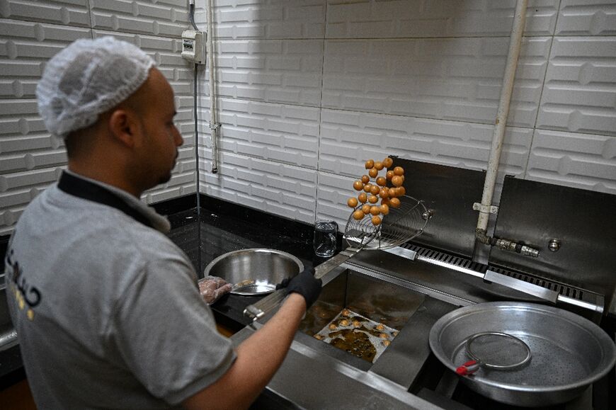 An employee fries sweet pastry at the restaurant -- the Sudanese style involves more salt