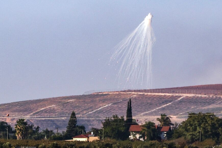 This picture taken from the moshav Kfar Yuval in northern Israel shows a shell fired by Israeli troops, exploding over hills in southern Lebanon on November 9, 2023