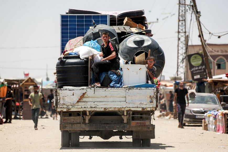 A family moves solar panels, cisterns and other items in Rafah, from where the United Nations says around one million people have been displaced since May 2024
