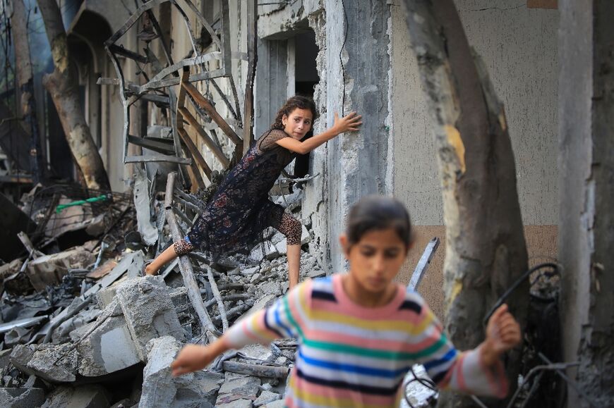 A Palestinian girl climbs over debris in Nuseirat a day after the Israeli special forces operation