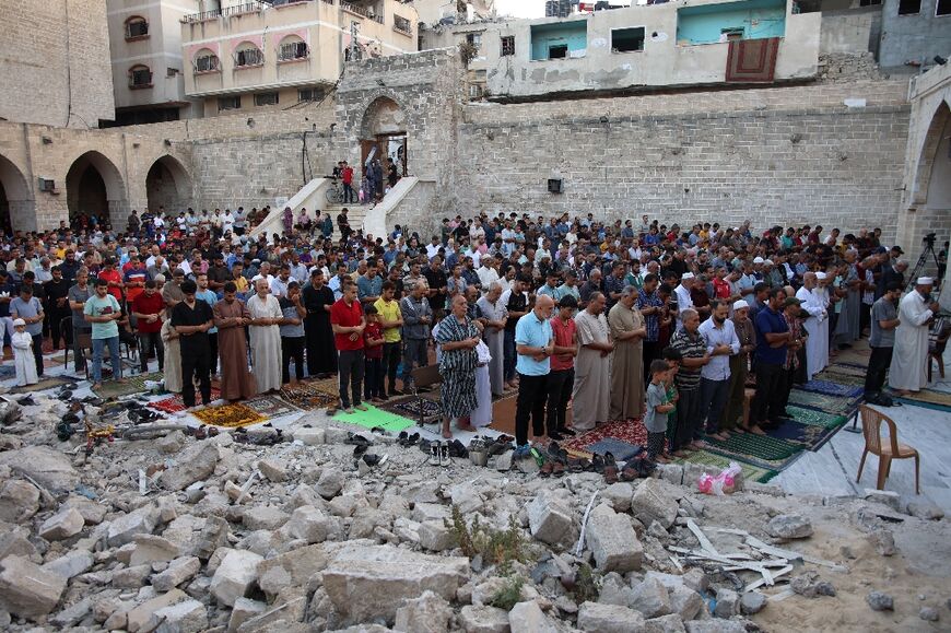 Palestinians perform the Eid al-Adha morning prayer in the courtyard of Gaza City's historic Omari Mosque, damaged in Israeli bombardment