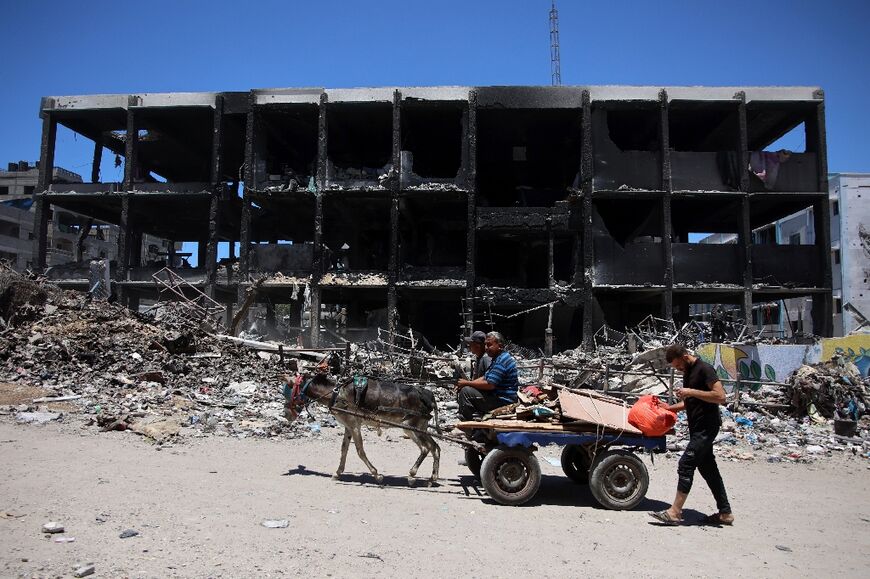 Palestinians transport salvaged belongings as they leave the Jabalia refugee camp in the northern Gaza Strip after returning briefly to check on their homes