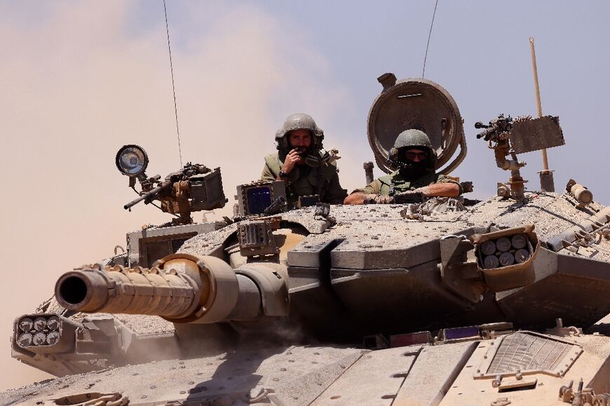 An Israeli army tank rolls to take position in an area along Israel's southern border with the Gaza Strip