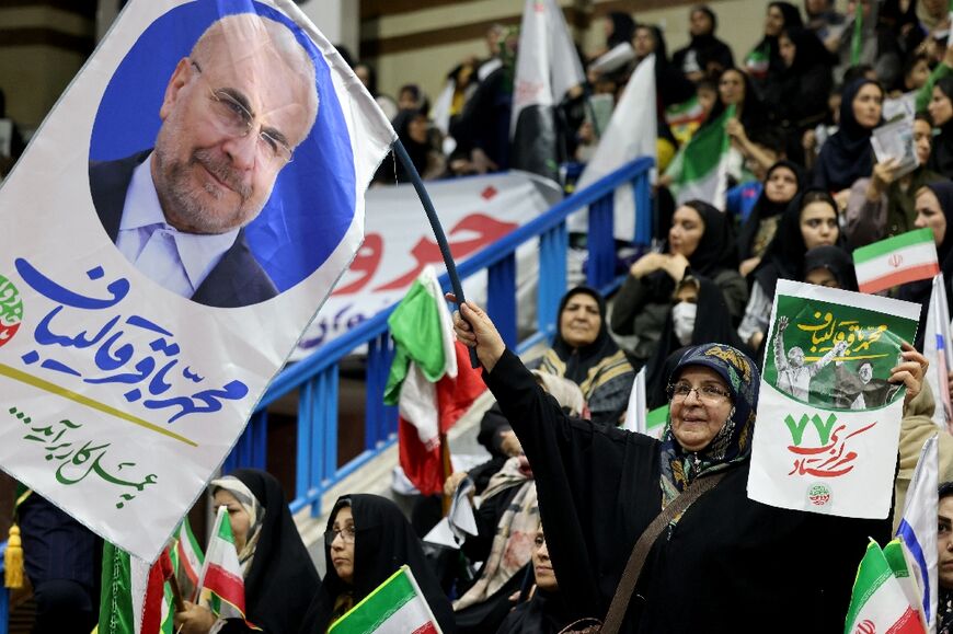 An Iranian woman waves a banner in support of conservative parliament speaker Mohammad Bagher Ghalibaf at a rally in Tehran