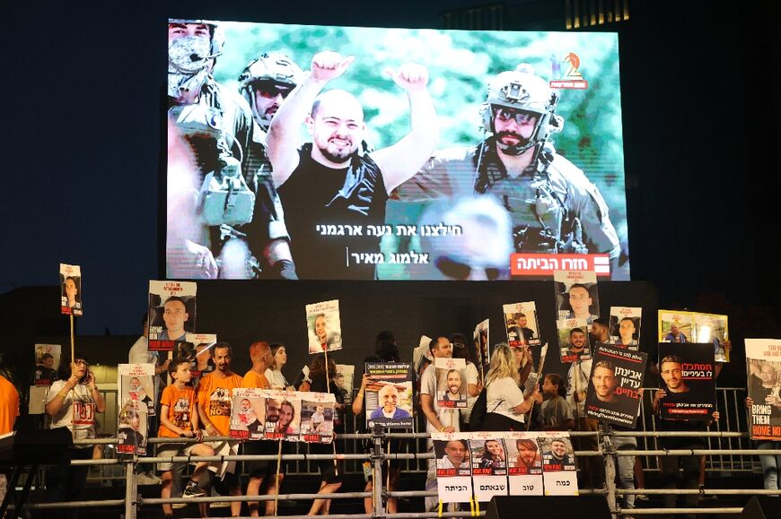 A rescued hostage is seen on a large screen at a rally in Tel Aviv by relatives and supporters of Israelis taken captive in Gaza in the October 7 attacks
