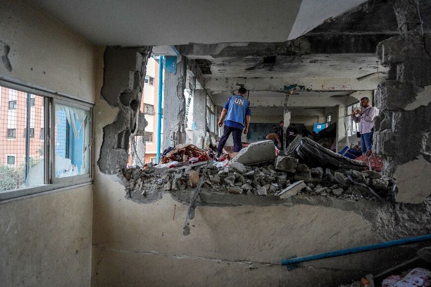 A member of the United Nations checks a UN-run school housing displaced people that was hit during Israeli bombardment in Nuseirat refugee camp