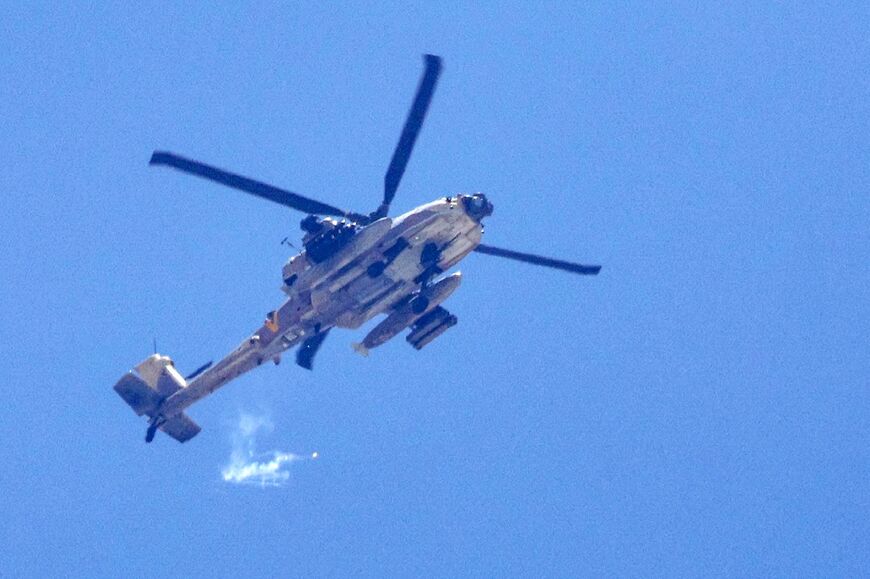 An Israeli attack helicopter fires flares while flying near the border with the Gaza Strip