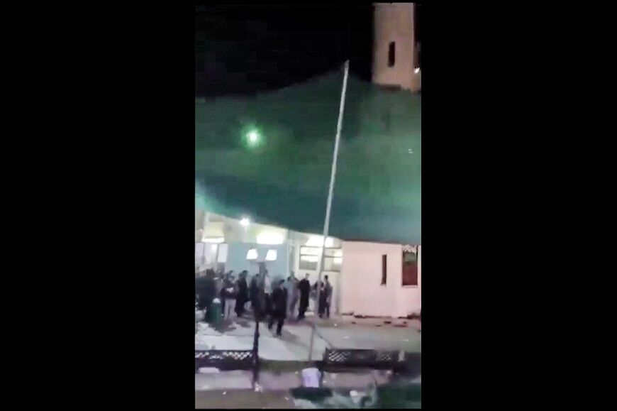 This image grab from a UGC video shows people fleeing a shooting at the Imam Ali Mosque in the Omani capital Muscat which police say killed four people