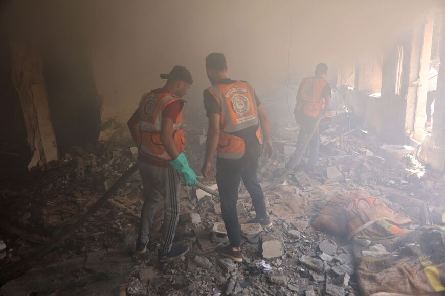 Palestinian civil defence workers in Gaza City's Latin Patriarchate Holy Family School after it was hit during Israeli bombardment