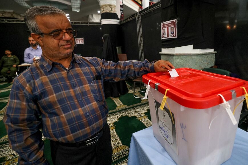 An Iranian man casts his ballot at a polling station in Tehran