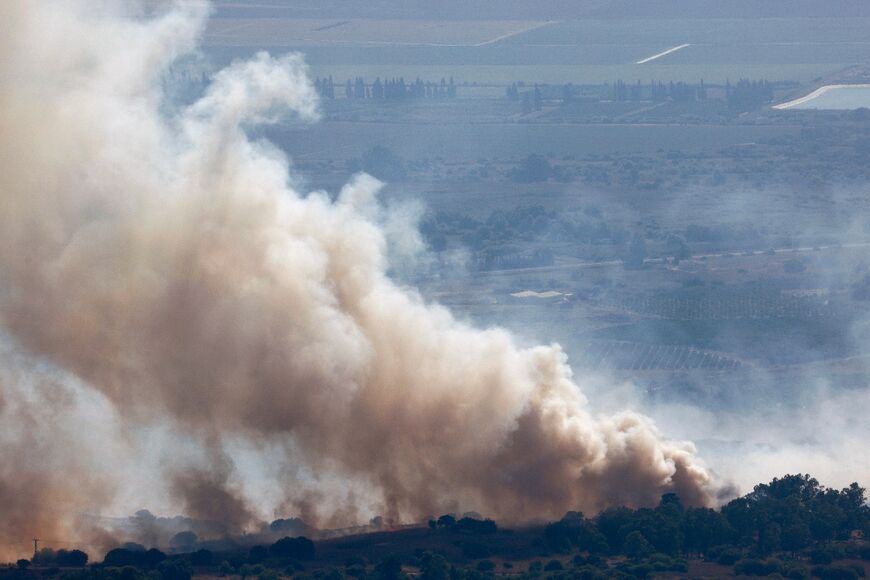 Smoke billows over the Upper Galilee region in northern Israel after a hit from a rocket fired from southern Lebanon
