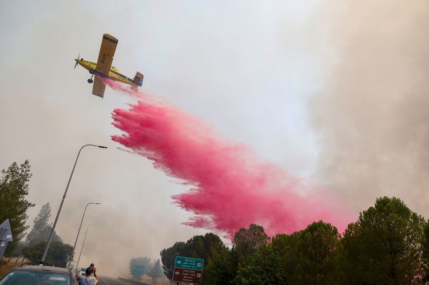 An Israeli plane drops flame retardant on fires after rockets launched from southern Lebanon hit areas in northern Israel