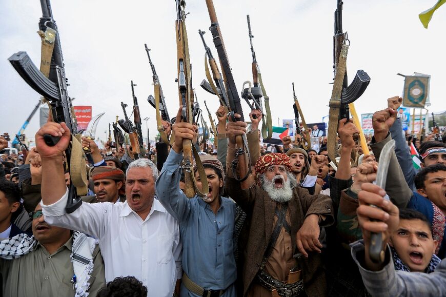 Huthi supporters brandish rifles at a Palestinian solidarity rally in the rebel-controlled Yemeni capital Sanaa just hours after the drone strike on Tel Aviv