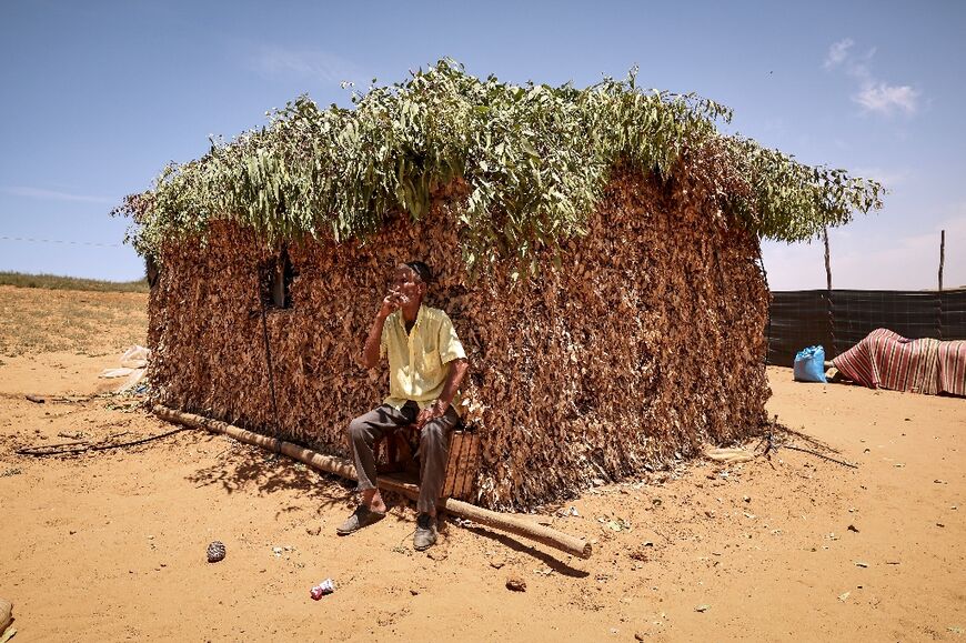 A farmer smokes during a break outside his house in the parched lands around Sidi Slimane