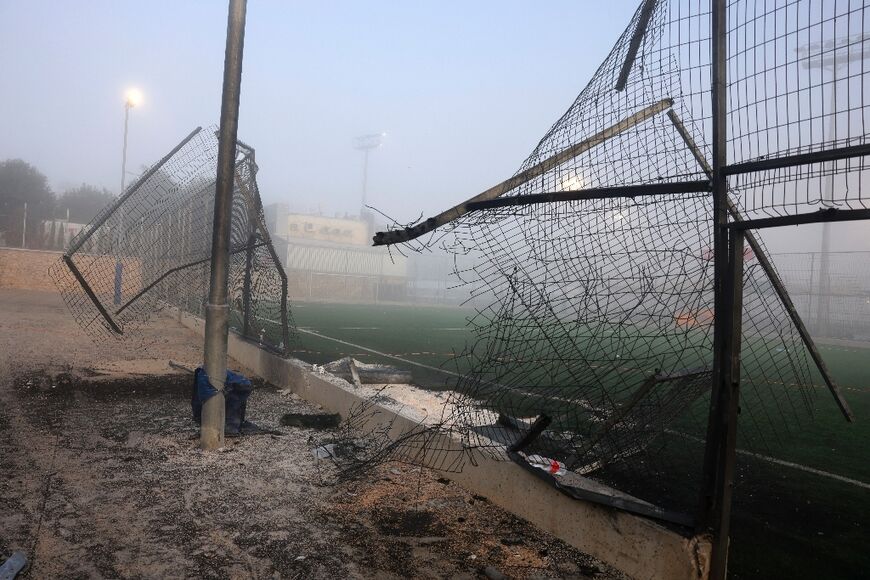 A damaged gate and debris after the rocket strike at the football pitch