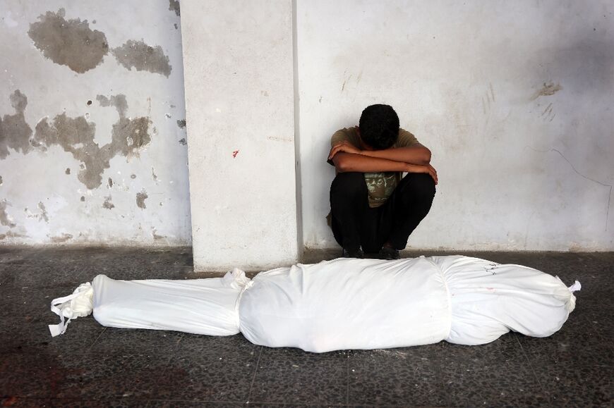 A man mourns a relative at a hospital in Gaza following an Israeli strike that killed more than 90 people at a school sheltering displaced Palestinians