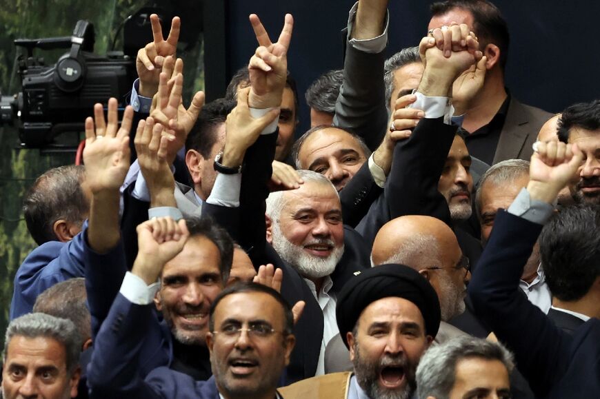 A day before his killing, Ismail Haniyeh, political chief of Palestinian militant group Hamas (C), flashes the victory sign among other officials during the swearing-in ceremony for Iran's new president