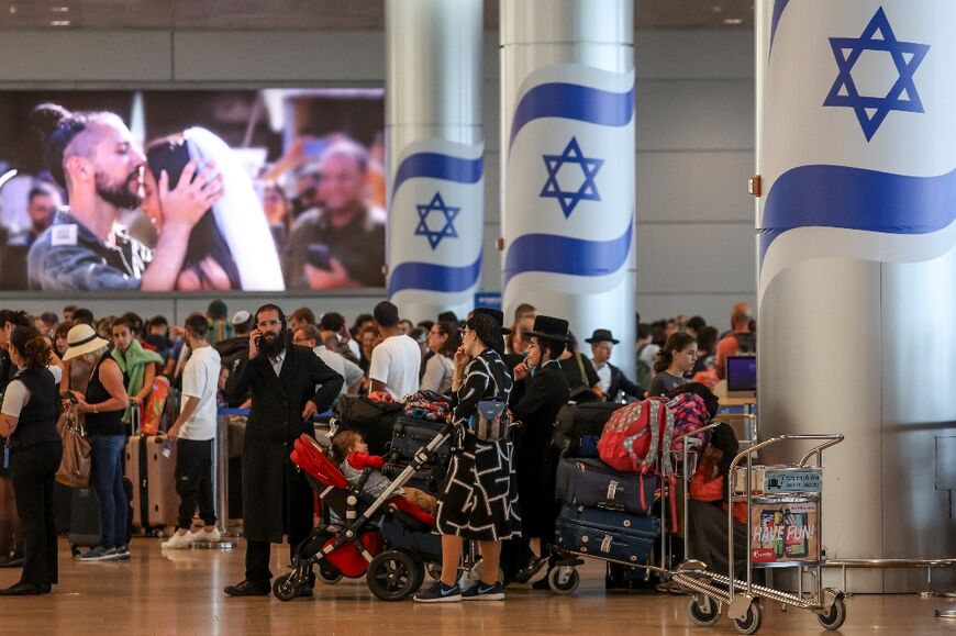 Passengers line up to check in at Ben Gurion airport near Tel Aviv, amid flight cancellations and delays due to surging regional tensions