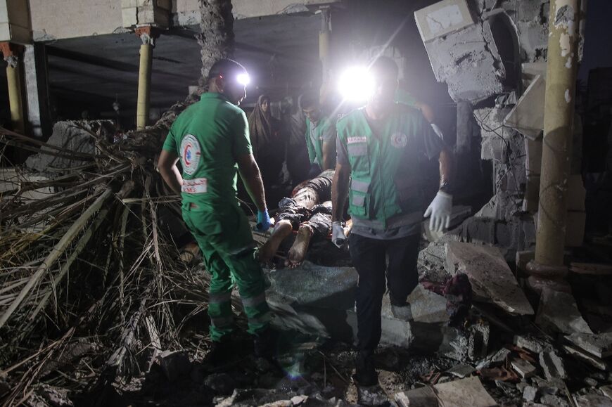 Rescuers search for victims following an Israeli strike on Al-Tabieen school in Gaza City