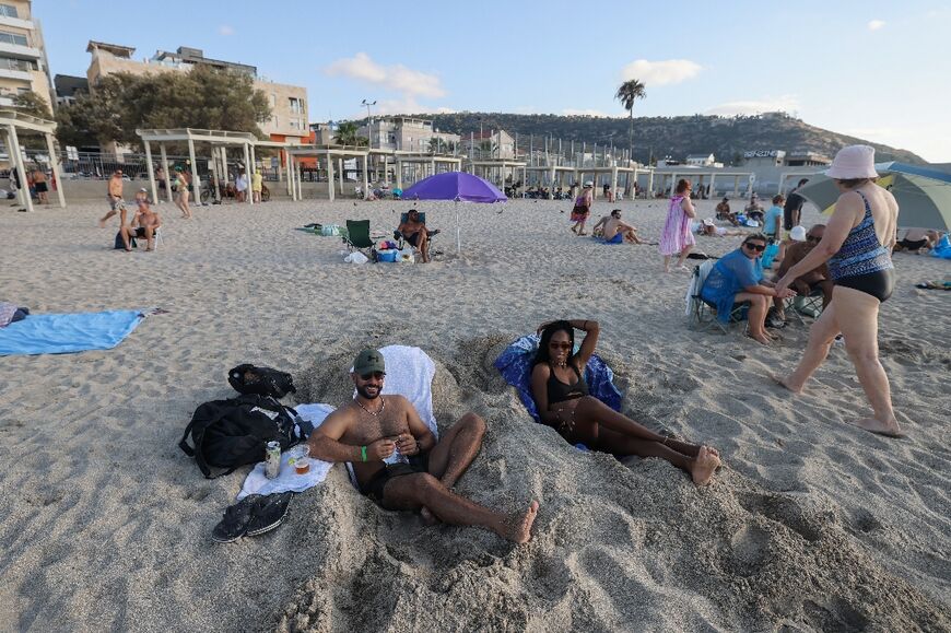 People sunbathe at the beach in Israel's northern coastal city of Haifa on Sunday, despite fears of an attack by Iran and Hezbollah
