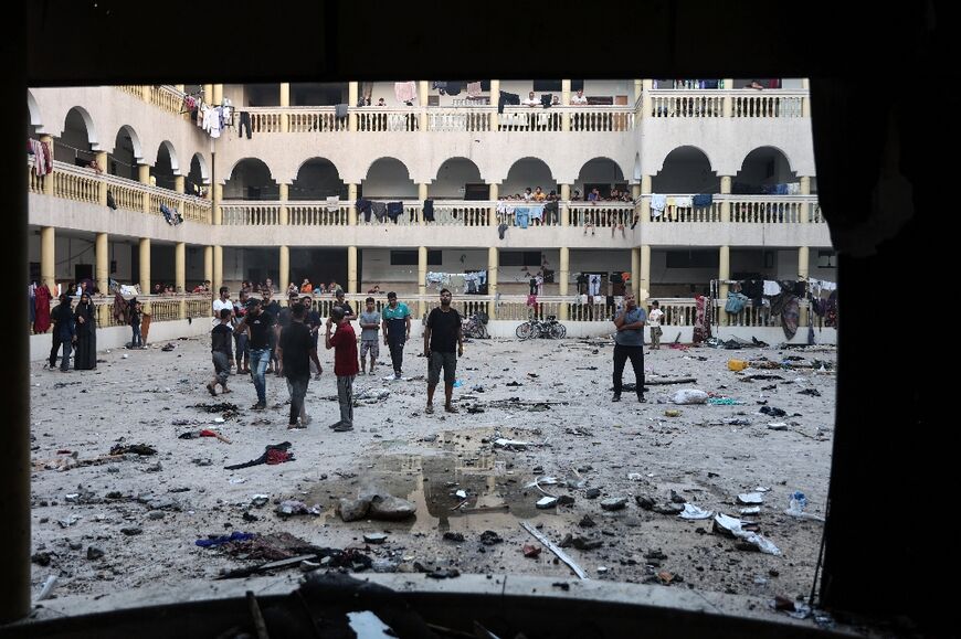 Displaced Palestinians gather in the courtyard of the school after the strike