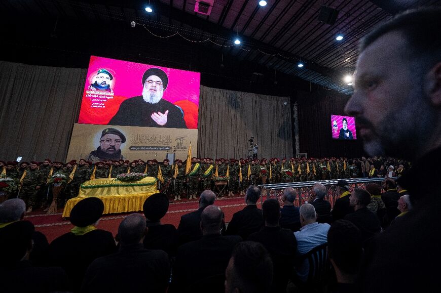 A televised speech by Hezbollah chief Hassan Nasrallah is transmitted during Fuad Shukr's funeral ceremony in Beirut