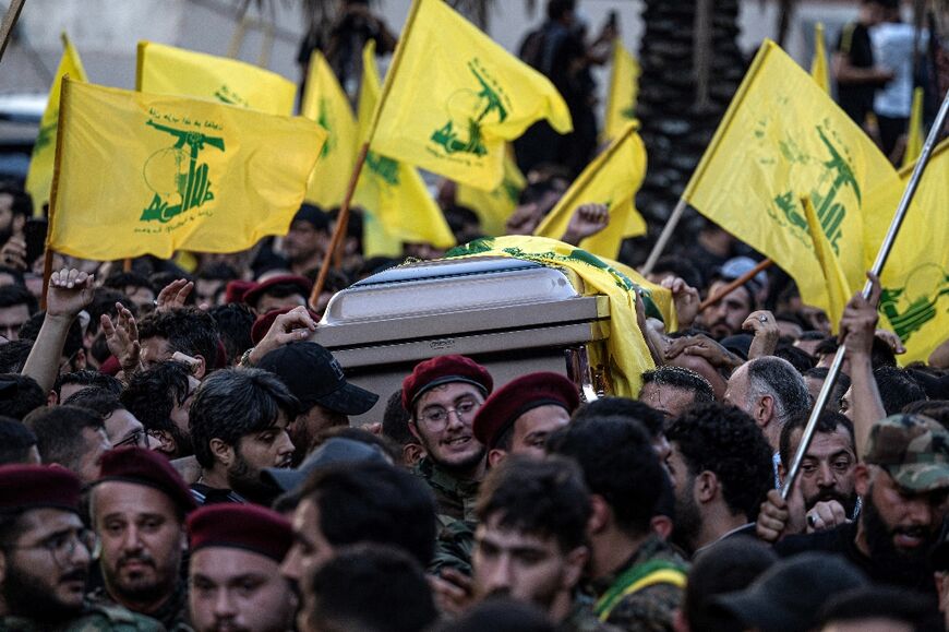 Hezbollah fighters carry the coffin of slain commander Fuad Shukr in a funeral procession through Beirut's southern suburbs on Thursday
