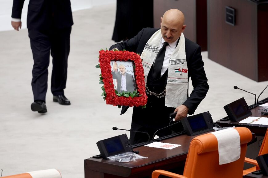 A picture of slain Hamas chief Ismail Haniyeh framed by red carnations was displayed inside parliament as Abbas spoke