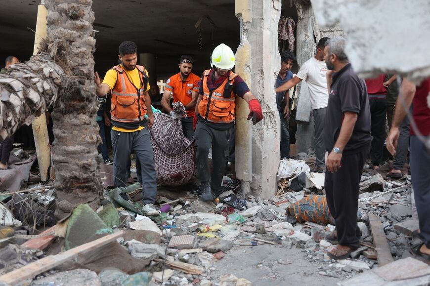 A corpse is removed after an Israeli strike on a school sheltering displaced people in Gaza City