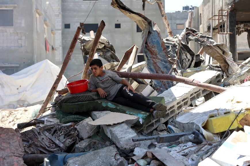 A Palestinian boy sits amid the rubble near a food distribution point in in northern Gaza's Jabalia refugee camp